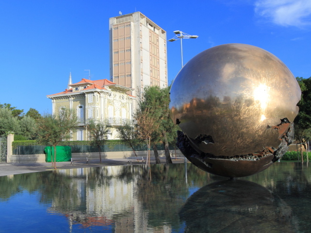 Скульптура на фоне зданий на курорте Пизавр, Италия