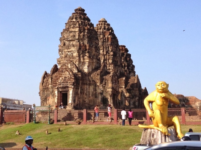 Золотая обезьяна на фоне храма на курорте Лопбури, Таиланд
