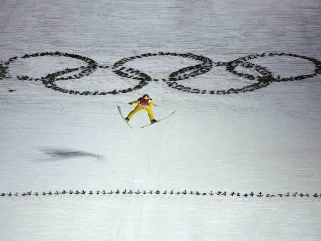 Спортсмен на фоне Олимпийских колец на Олимпиаде в Сочи