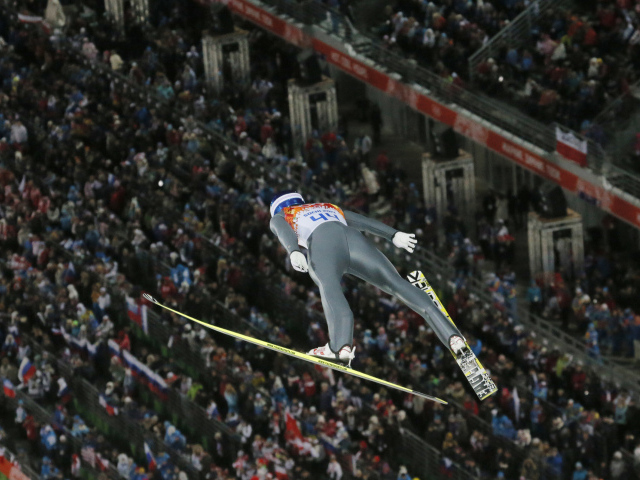 Прыжок с трамплина на фоне трибун на Олимпиаде в Сочи