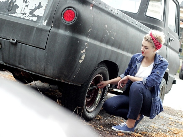 Девушка чинит автомобиль