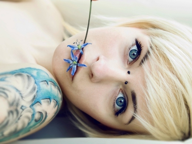 Девушка с синей татуировкой на плече
