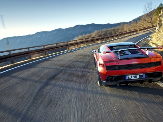 Красный гоночный автомобиль на горной дороге