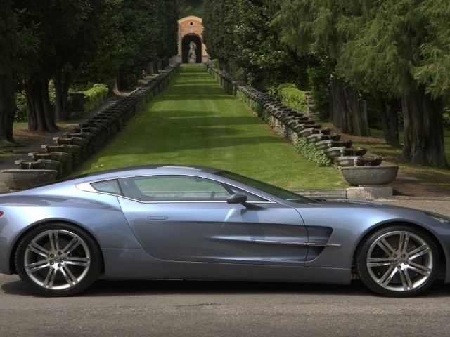 Спортивный Aston Martin на фоне аллеи