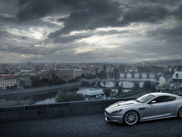 Серый Aston Martin на фоне города