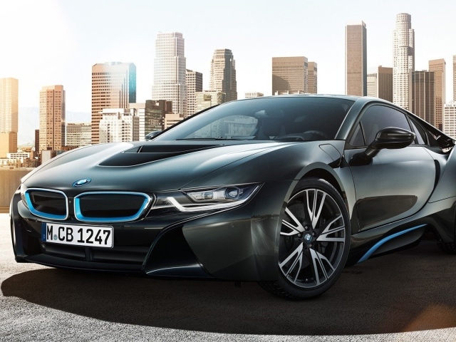 Спортивный черный БМВ на фоне мегаполиса