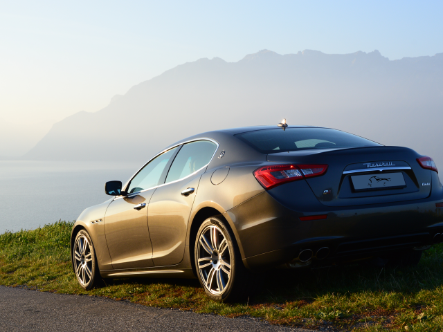 Коричневый Maserati на фоне гор