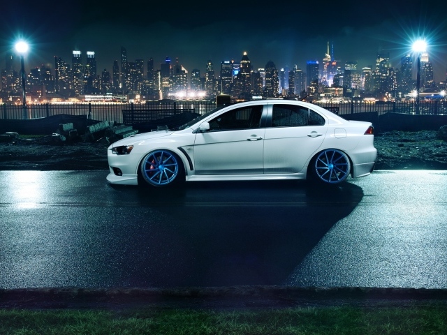 Автомобиль Mitsubishi Lancer Evo X на фоне города