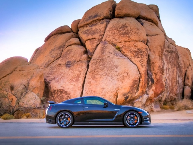 Черный Nissan GT-R у подножия скалы