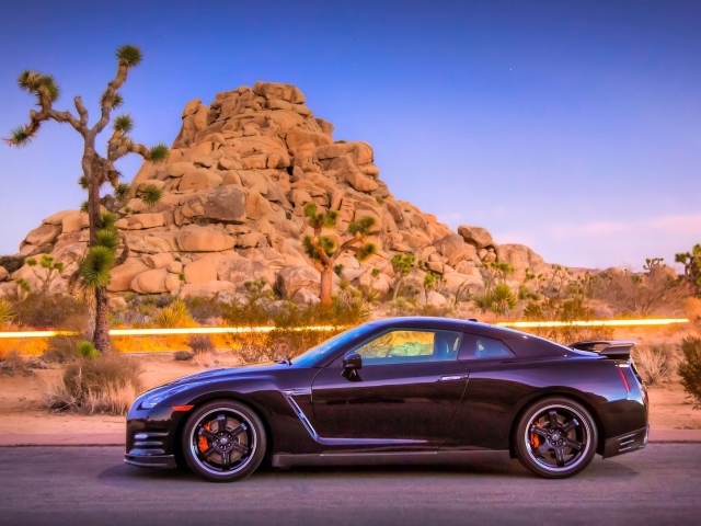 Автомобиль Nissan GT-R на фоне скалы