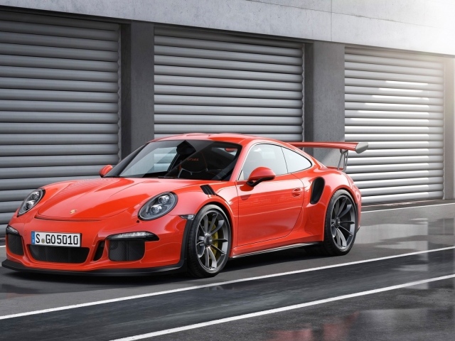 Красный Porsche 911 GT3 RS у ворот гаражей