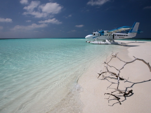 Самолет сел на воду у белого пляжа