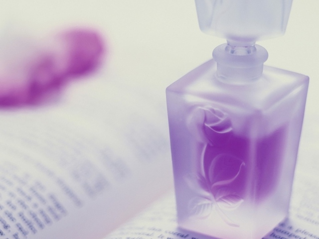 Флакон духов на открытой книге