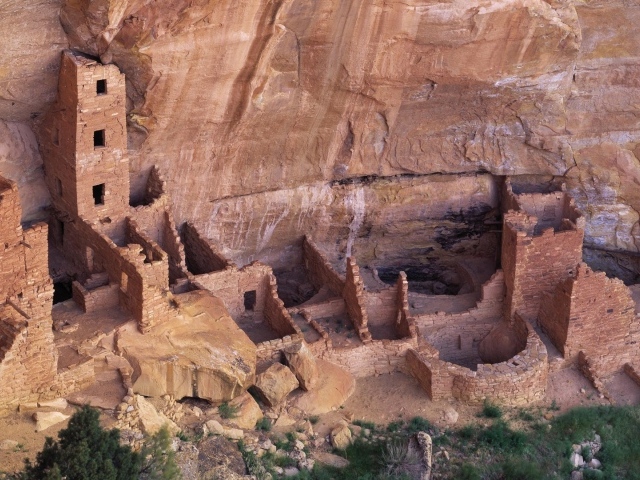 Руины каменных домов под скалой