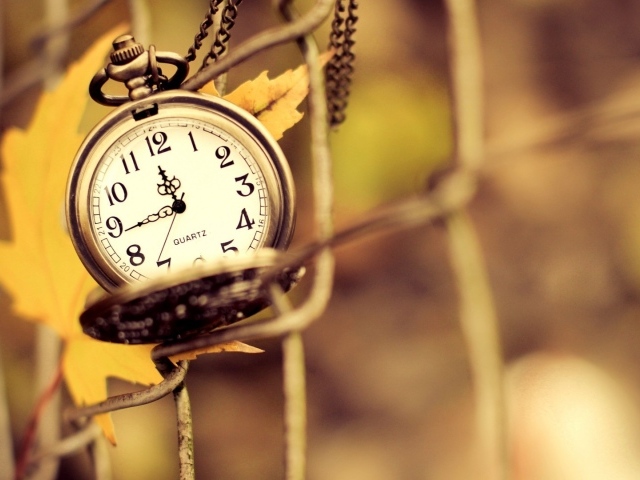 Часы на цепочке и осенний лист