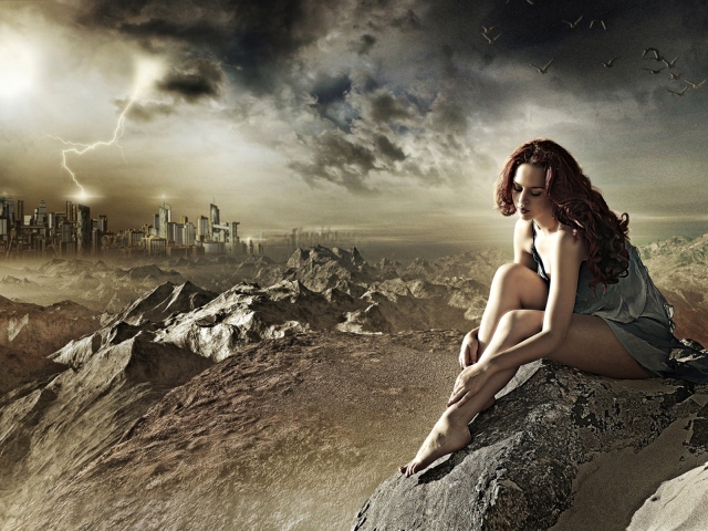 Девушка сидит на камне за городом