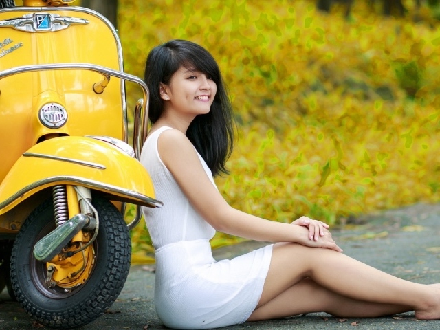Азиатская девушка у желтого мотороллера