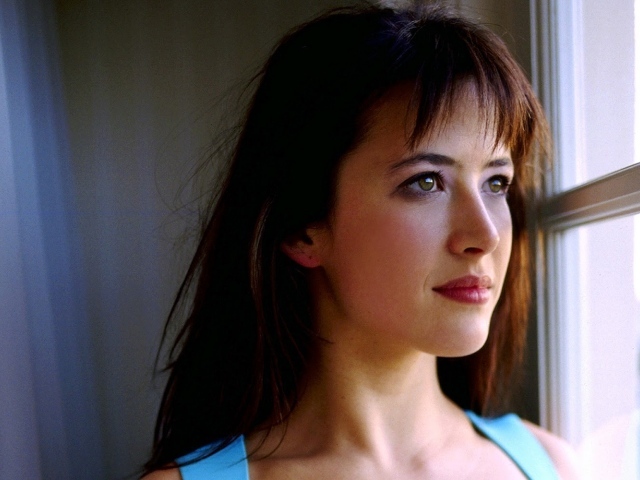 Красивая девушка смотрит в окно