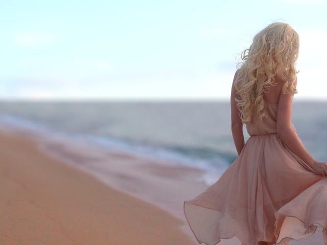 Блондинка в легком платье на пляже