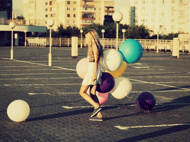 Связка воздушных шаров в руках юной девушки