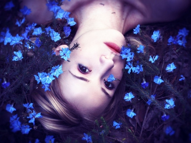 Девушка среди маленьких голубых цветов