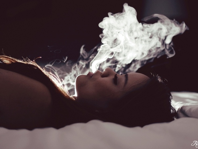 Девушка выпускает дым изо рта