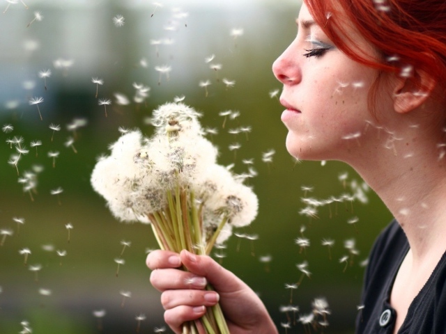 Девушка держит в руках букет одуванчиков