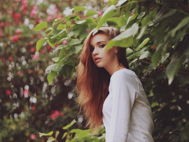 Девушка в белом платье гуляет в саду