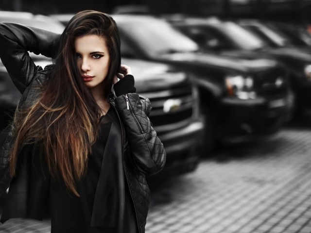 Черноволосая девушка на фоне черных автомобилей