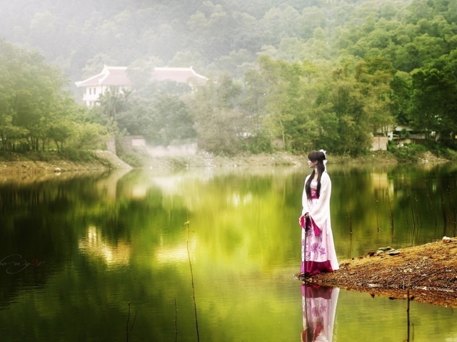 Японская девушка стоит на берегу водоема