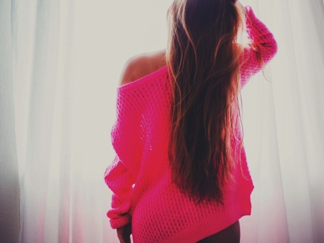 Девушка в розовой кофте стоит спиной