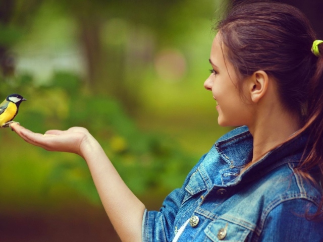 Синица сидит на руке у девушки