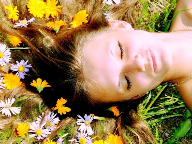 Белые и желтые цветы в волосах у девушки