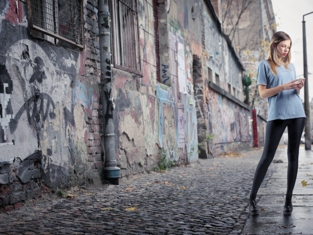 Молодая девушка стоит на улице в трущобах