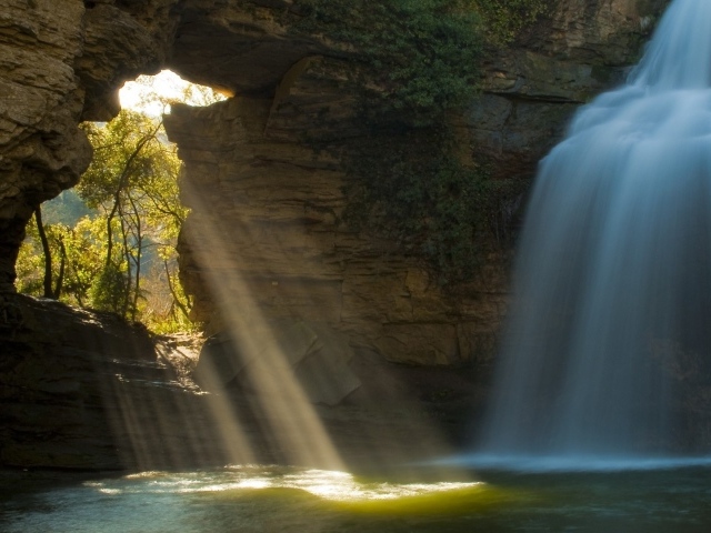 Лучи солнца и вода падают в пещеру