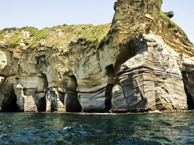 Промоины в основании скалы у моря