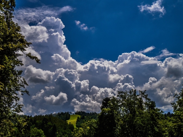 Кучевые облака над зелеными холмами