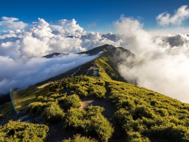 Зеленый горный хребет среди облаков