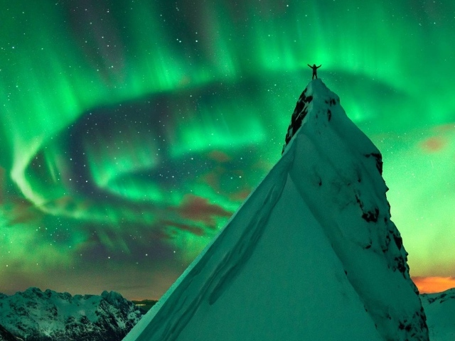Заснеженный пик на фоне северного сияния