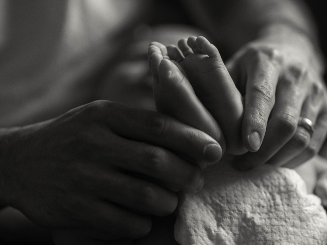 Ступни ребенка в руках отца