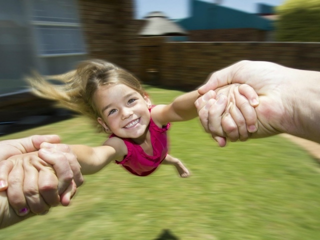 Веселая девочка в руках отца