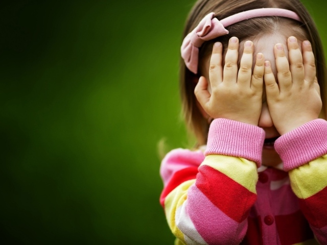 Милая девочка закрыла лицо руками