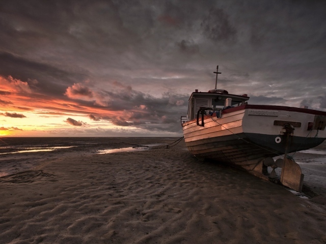 Лодка на песке пляжа во время отлива