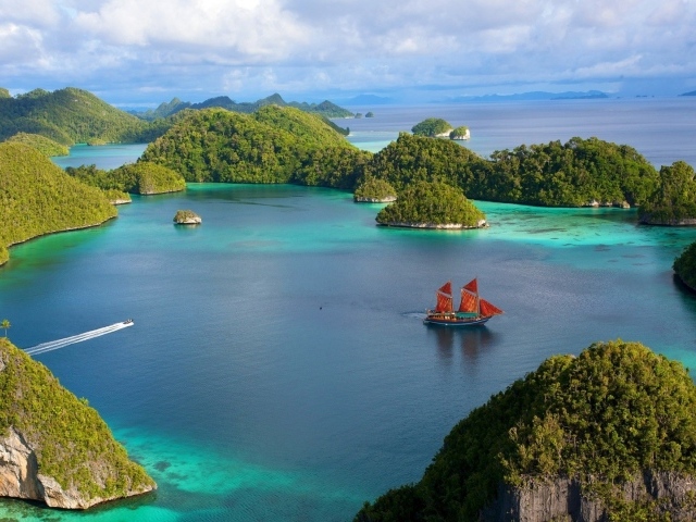 Корабль с красными парусами среди островов