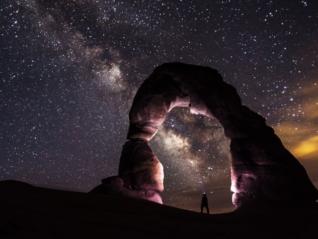Природная каменная арка на фоне звезд