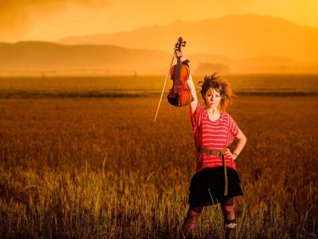 Скрипачка Линдси Стирллинг стоит в поле