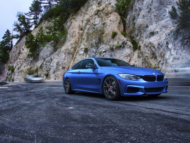 Голубой BMW M4 на фоне скалы