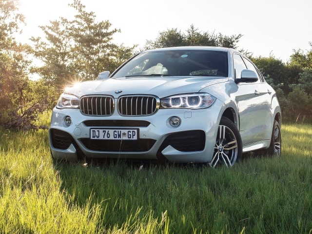 Белый BMW в поле за городом