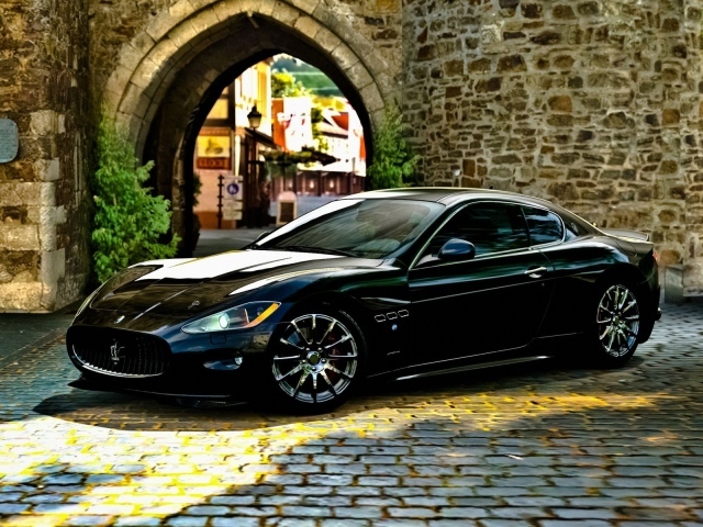 Черный Maserati gran turismo у каменной арки
