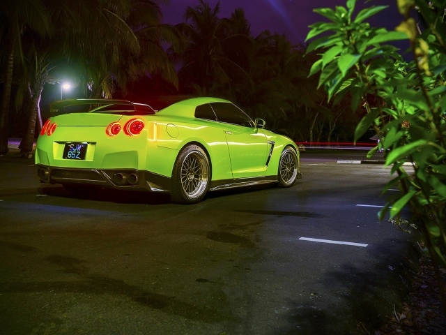 Зеленый спортивный Nissan на ночной улице города